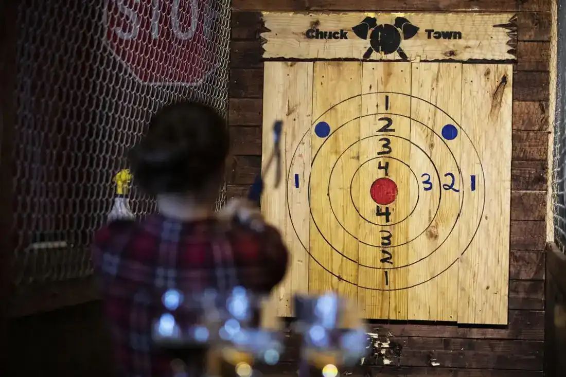 Guest lining up an axe throw at a painted target