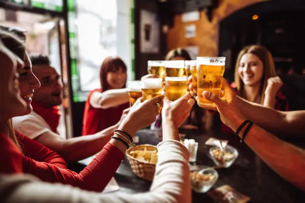 Friends raising beers at a brewpub