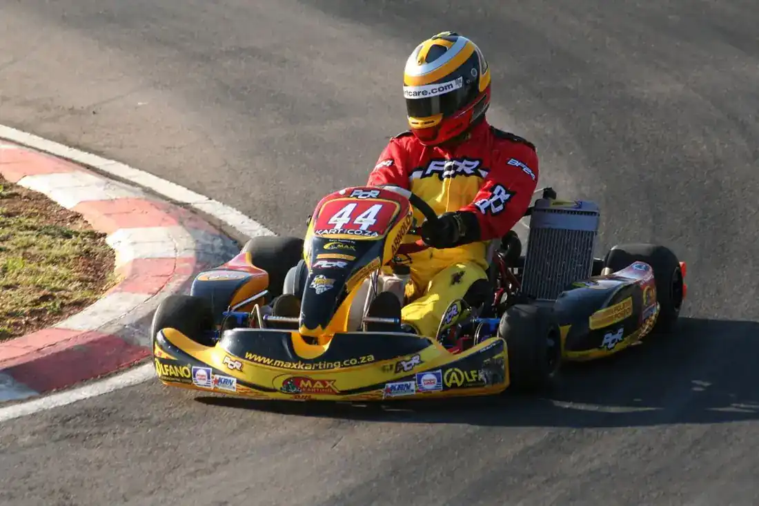 Go-kart racer in a yellow kart taking a corner