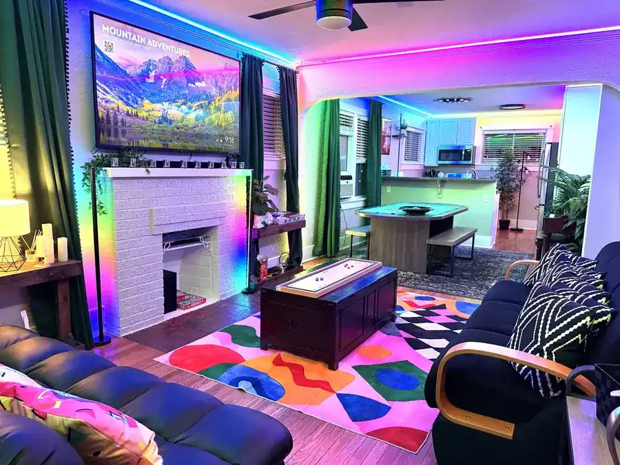 Vibe City RiNo Escape living room with game table and colorful rugs